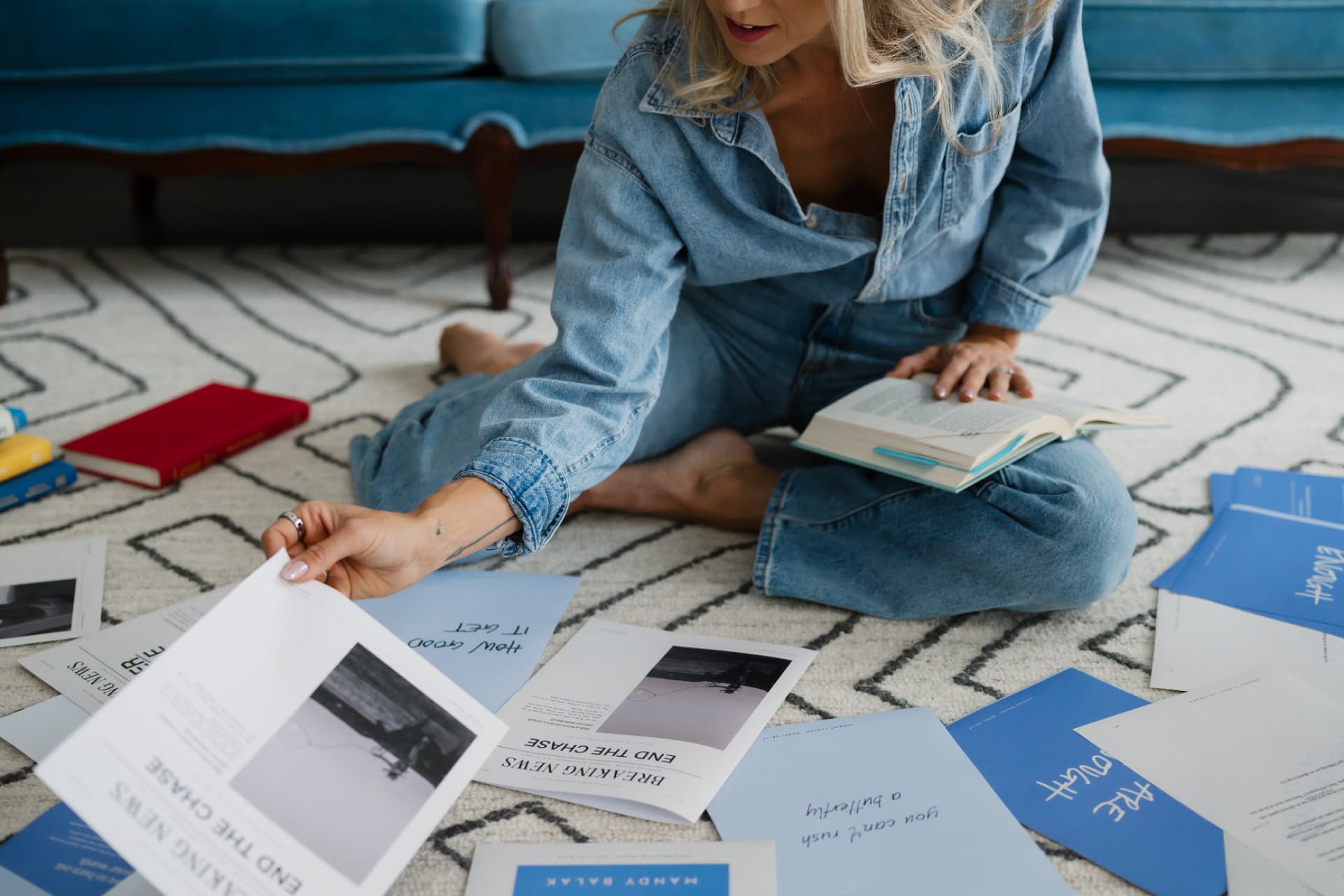 Mandy Balak sitting on the floor with printed pages from Chasing Enough